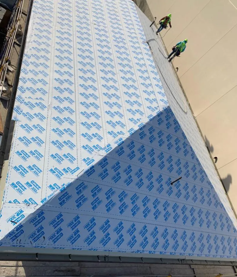 Professional roofers installing underlayment on a metal roof in Prospect Heights